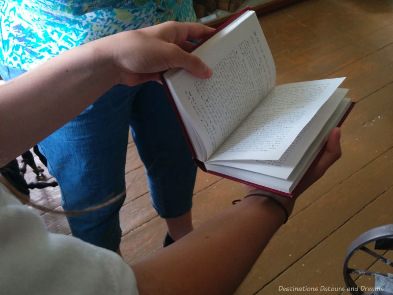 Hand holding a Cree prayer book at St Andrew's Rectory in Manitoba