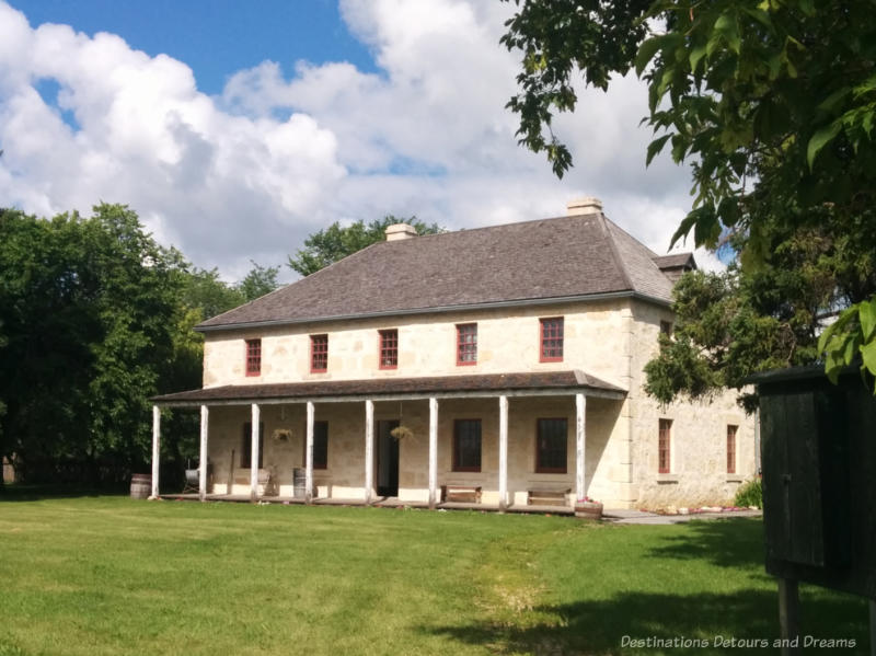 Limestone two story 1800s house with covered front porch - rectory in Manitoba