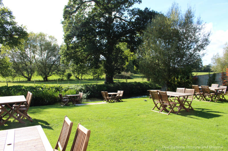 Wood tables on a pub lawn beside a river