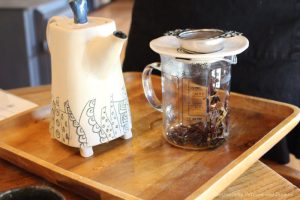 clay tea and and glass pitcher containing loose tea
