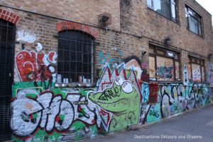 London street art in Brick Lane: graffiti-like drawing in the aley leading to Seven Stars car park