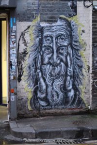London street art in Brick Lane: monochrome paste-up of an old man by U.S. artist Pyramid Oracle
