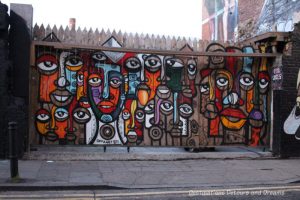 London street art in Brick Lane: painting of African masks by Senzart 911 (Senzo Nhlap) from Soweto,South Africa