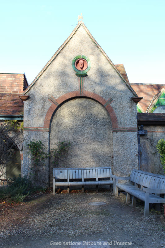 Benches outside stone facade of Watts Gallery