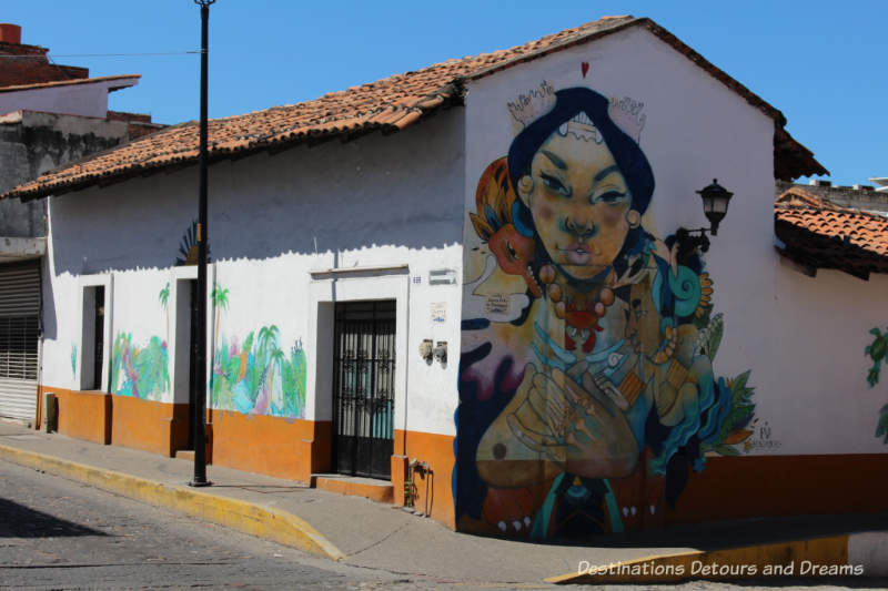 Puerto Vallarta street art: woman with outstretched folded hands, part of Restore Coral Mural project