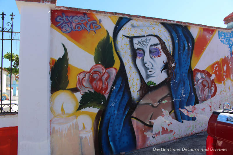 Mural of a woman and candles on the wall of El Panteón Cemetery in Puerto Vallarta