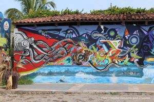 Puerto Vallarta street art: stylized picture of the sea with geometric shapes and octopus with arms reaching through the painting