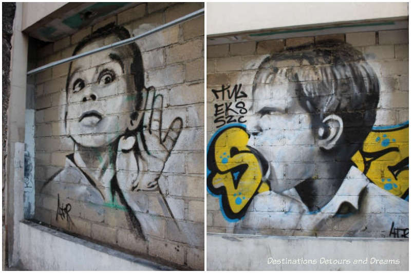 Puerto Vallarta street art: two murals in black and white, one of an angry boy shouting, one of a boy with hand to ear to listen