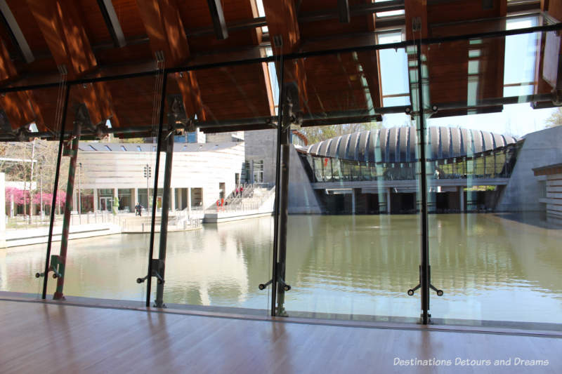 View of pond and more of the building out a wall of windows at Crystal Bridges Museum of American Art