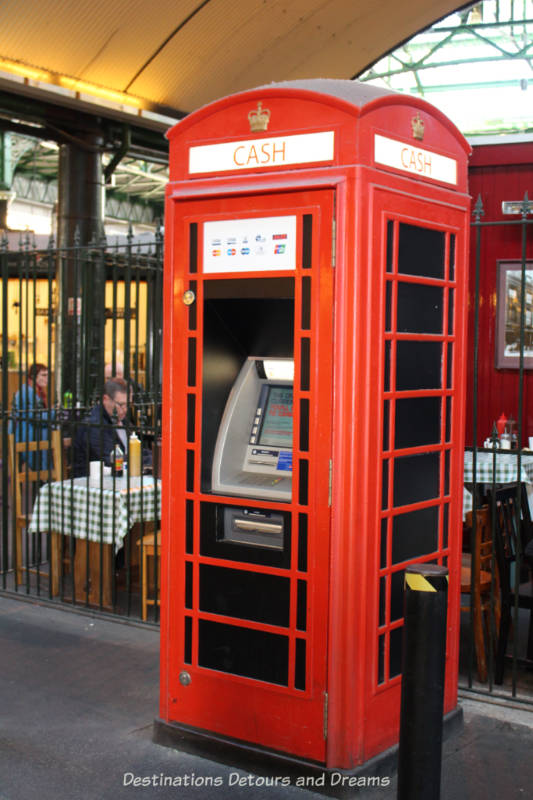 Red phone booth used as an ATM station in Borough Market