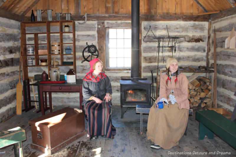 Costumed interpreters inside a cabin at Fort Gibraltar