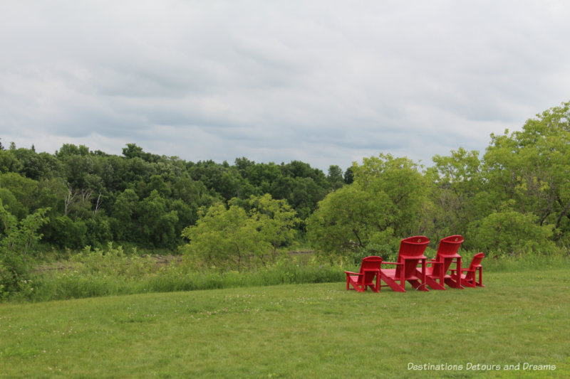 Big red Parks Canada chairs on the grounds of Lower Fort Garry