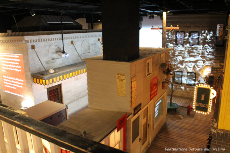 View of the street in the Manitoba Museum Urban Gallery with a digital projection of 1919 Strike photos on one wall