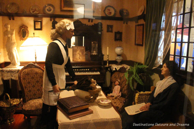 Woman and her maid mannequins inside a 1919 drawing room at the Manitoba Museum Urban Gallery