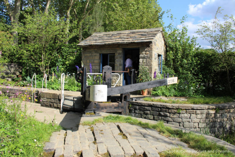 Canal and lock surrounded by greenery at the Welcome to Yorkshire Garden at the 2019 Chelsea Flower Show