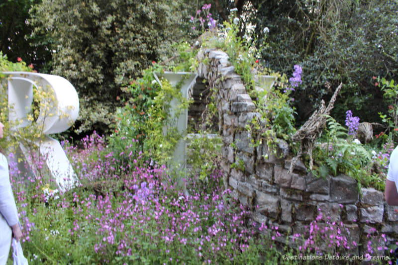 Flowers growing around and up a crumbling stone wall on the Wild Walls display at the 2019 Chelsea Flower Show