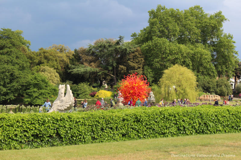 Chihuly's Summer Sun glass sculpture amid plantings and trees at Kew Gardens