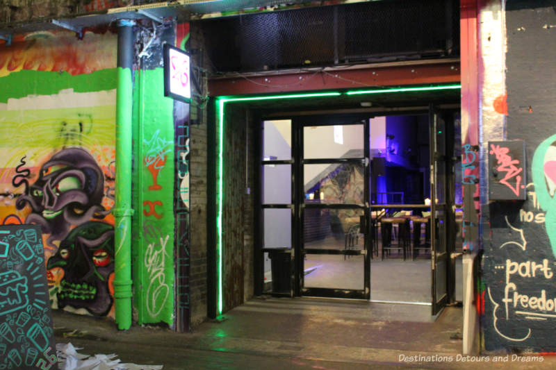 London Graffiti Tunnel: Railway Arch Venue Doors from London Leake Street Tunnel through an archway reveal an entertainment venue