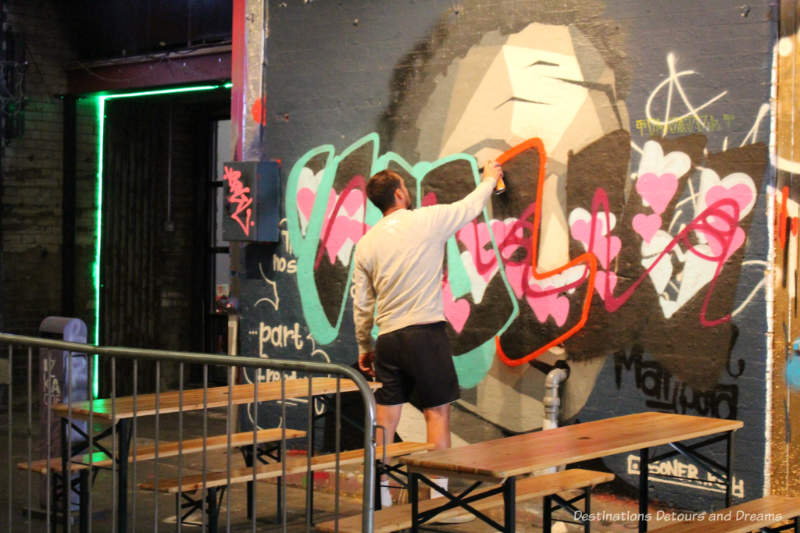 London Graffiti Tunnel: Artist at Work Artist spray painting in London Graffiti Tunnel