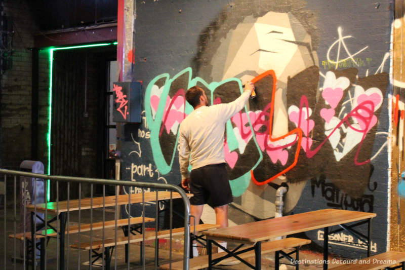 Artist spray painting in London Graffiti Tunnel 