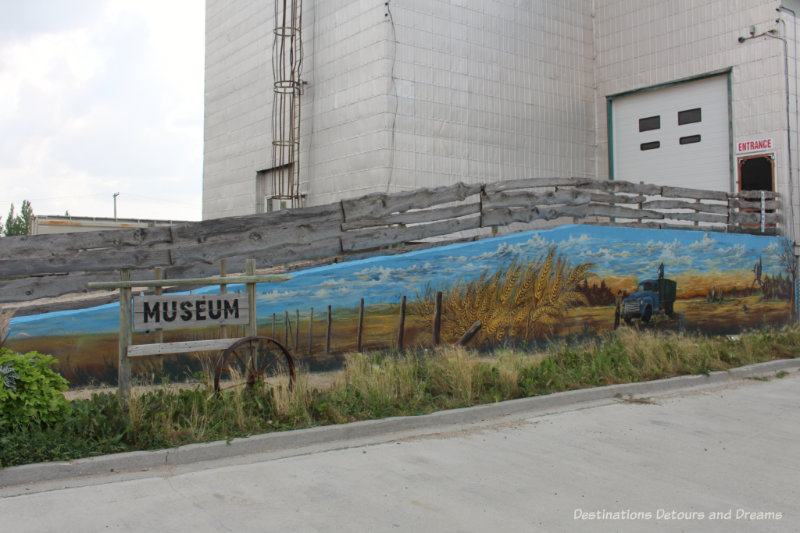 A grain elevator with a mural painted on it houses a museum in Plum Coulee, Manitoba