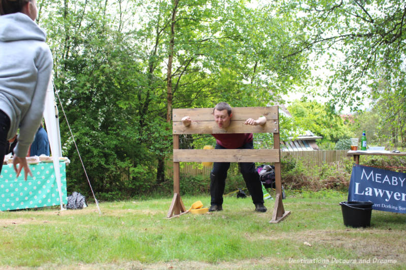English Village Fête: Sponge Throwing Man in stocks for wet sponge throwing game at an English village fête