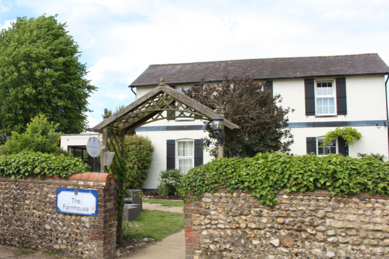 Farmhouse behind vine-covered stone fence on the Denbies Wine Estate operates as a bed and breakfast