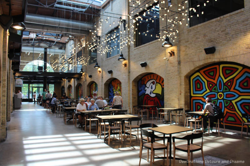 Part of the food court at The Forks Market with aboriginal-style murals on brick walls