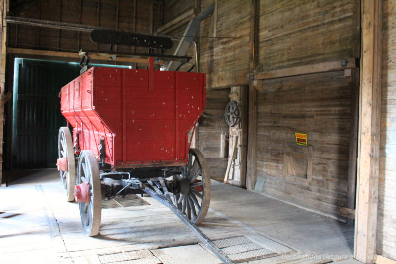 Red grain wagon inside an old wooden grain elevator