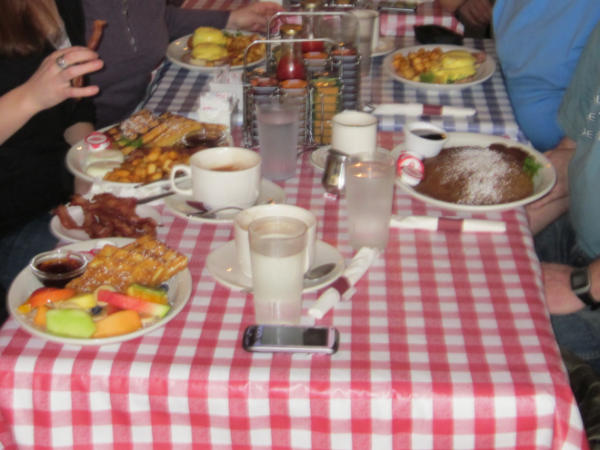 A table with a red and white tablecloth covered with brunch orders at Cafe Zen on Yew in Vancouver