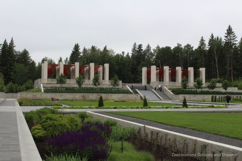 The Aga Khan Garden at U of A Botanical Garden: Geometric shaped grassy and flowered areas with crisscrossing pathways with the raised upper terrace in the background 