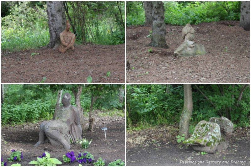 Collection of human-like statues tucked under trees at the University of Alberta Botanic Garden