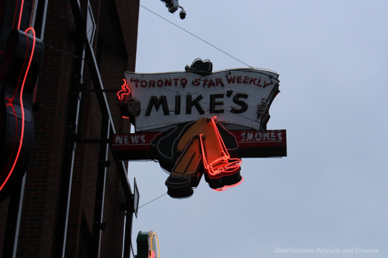 Mikes neon sign features man on a bench reading a Toronto Star Weekly Newspaper at the Edmonton Neon Museum