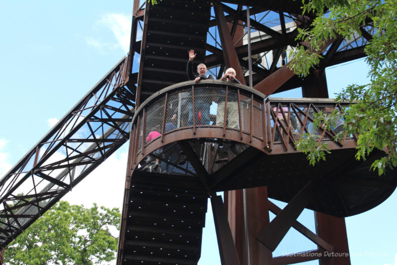 Man waving from one of the staircase levels of the Kew Treetop Walkway