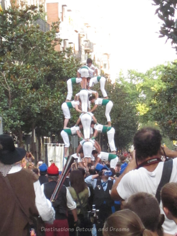 Acrobats forming a human pyramid at the Gracia Street Festival parade