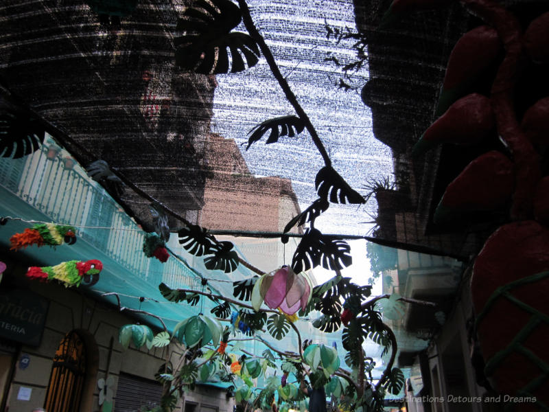 Parrots and other overhead street decorations at the Gracia Street Festival in Barcelona