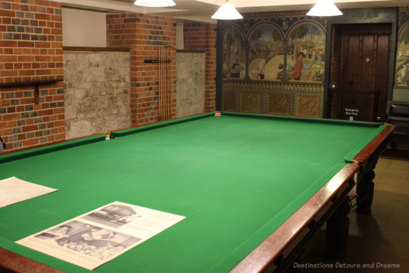 Billiards room featuring billiards table, brick side walls and mural on back wall at Eltham Palace