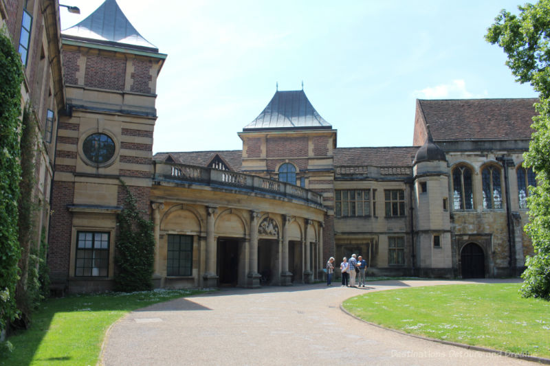 Low circular brick front of Eltham Palace with two-story wings to the sides and a driveway in front