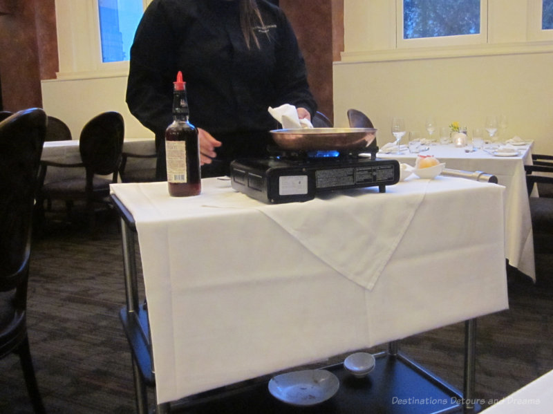 Server preparing flambe dessert at restaurant