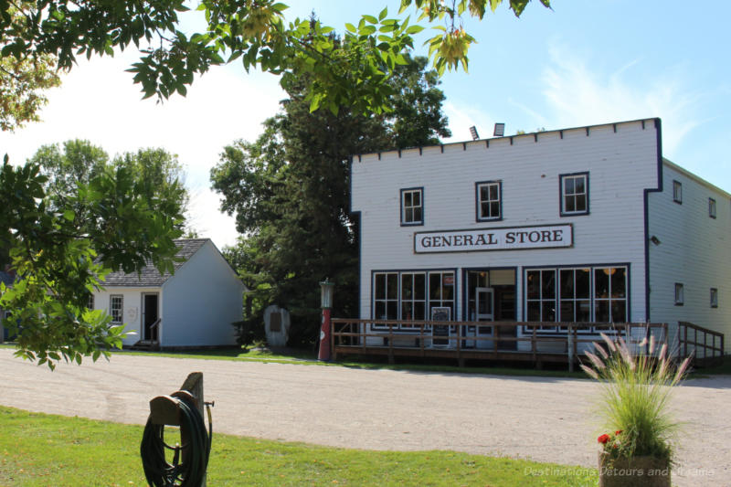 White wooden general store in front of a gravel street