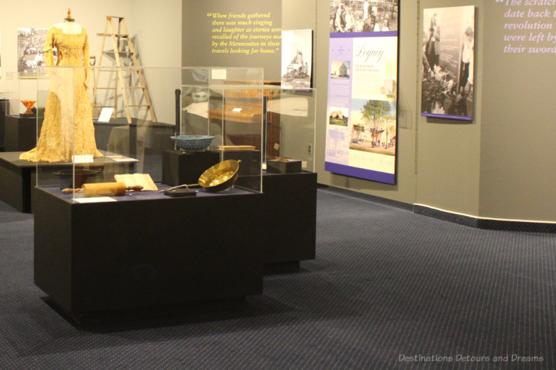 Walls of information and display cases in centre of room at Russländer exhibit at Mennonite Heritage Village