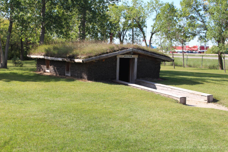 Sod house built partially underground with grass on roof