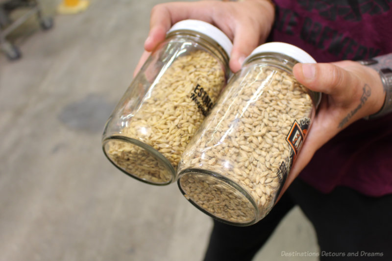 Woman holding two jars  of barley husks