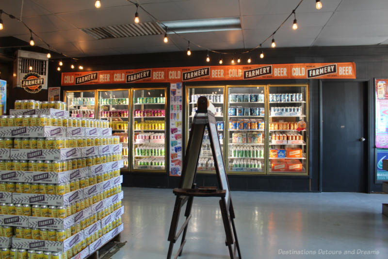 Cooler and stacks of beer and soda cans for sale