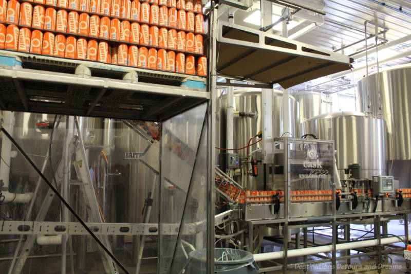 Canning machine filling orange cans of Famery beer