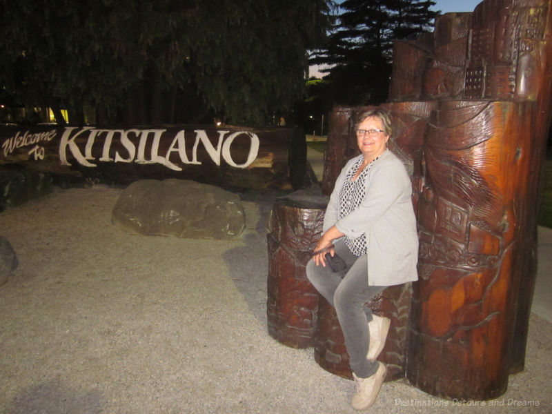 Wood sign and carved log sculpture is a welcome to Kitsilano