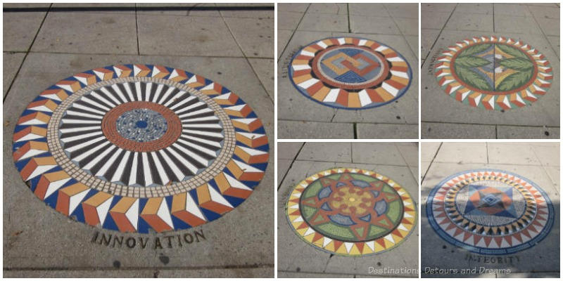A collage of five circular geometric designed mosaic art pieces in the sidewalk