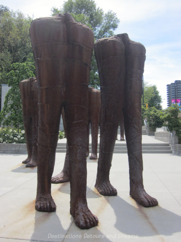 Iron statues of headless, torsless walking figures