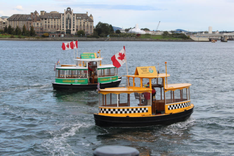 A green and a yellow Victoria Harbour Ferry boat