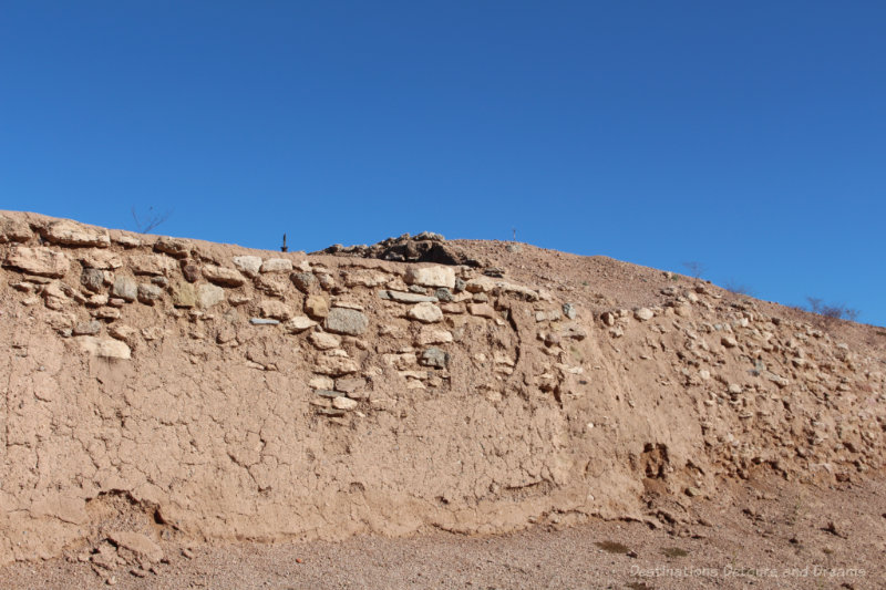 Soil and caliche wall that is the remains of an old Hohokam mound